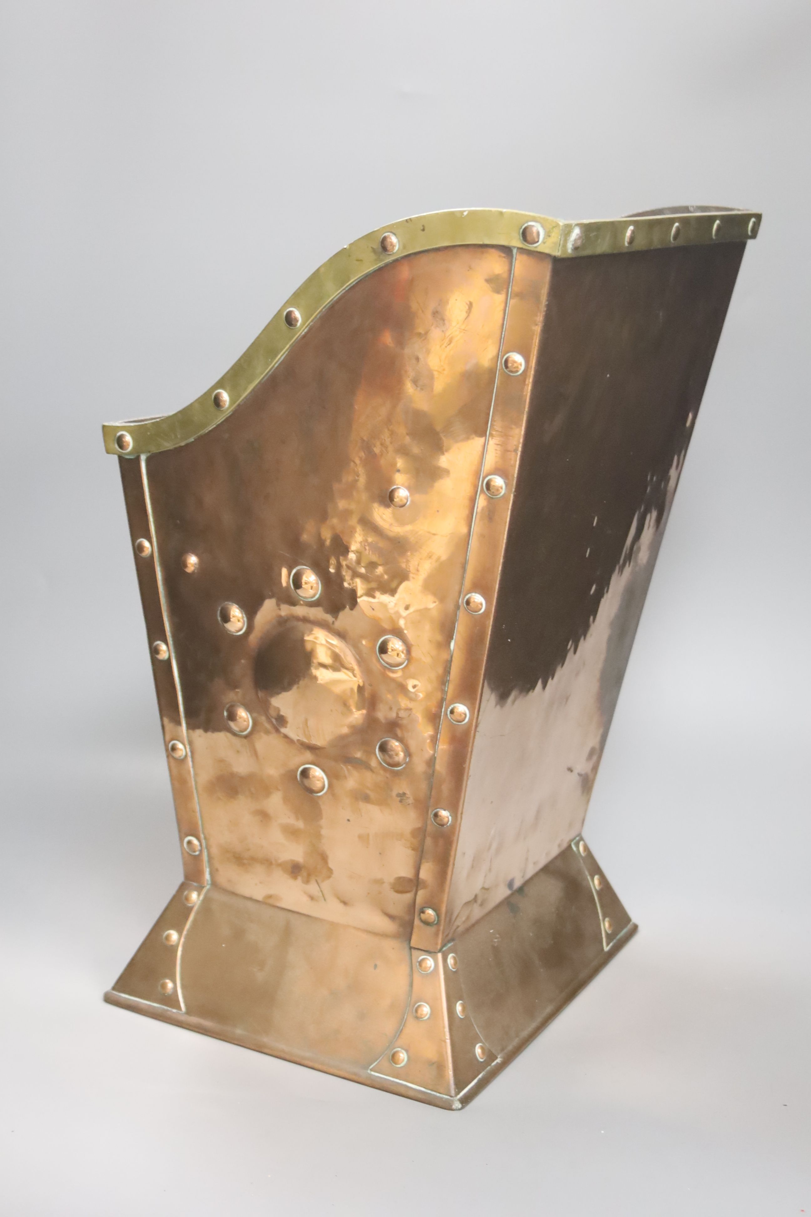 An Art Nouveau hammered copper coal box, with a brass rim